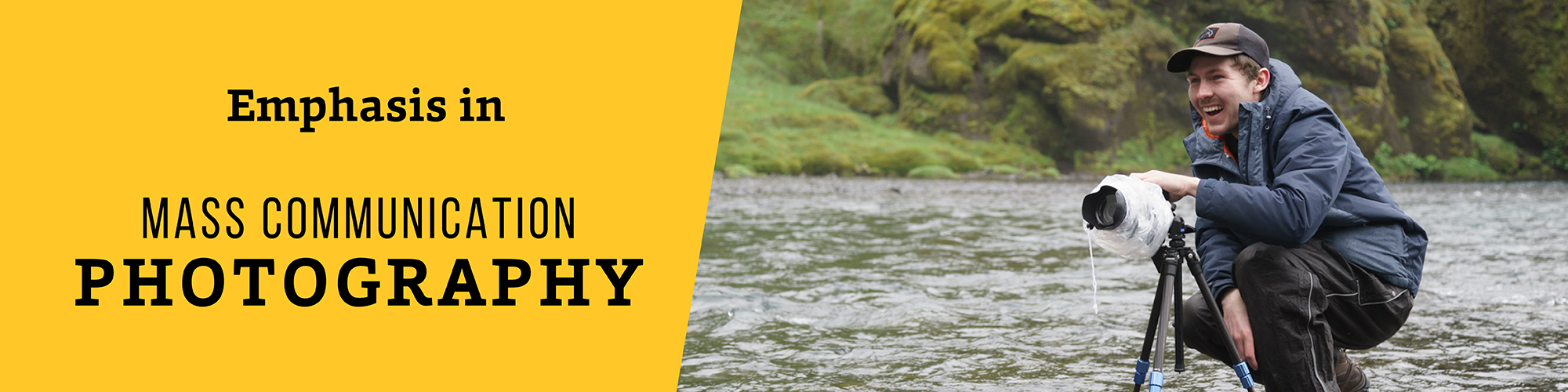 Emphasis in Mass Communication Photography; picture of BHSU photography student smiling while taking photos while in a river--hill in the background.