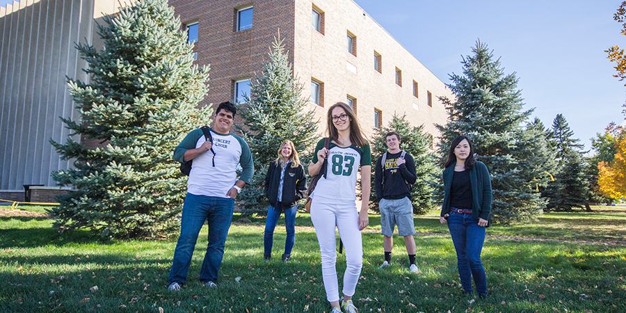 Four students pose outside.