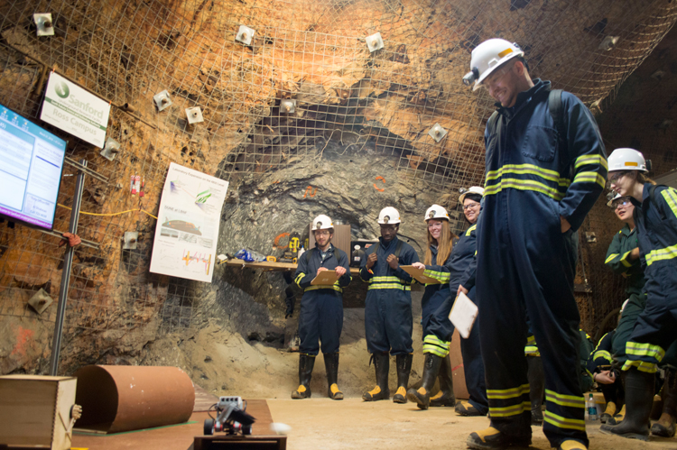 Seven people stand in the Sanford Underground Research Facility.