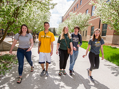 Five students walk around campus.