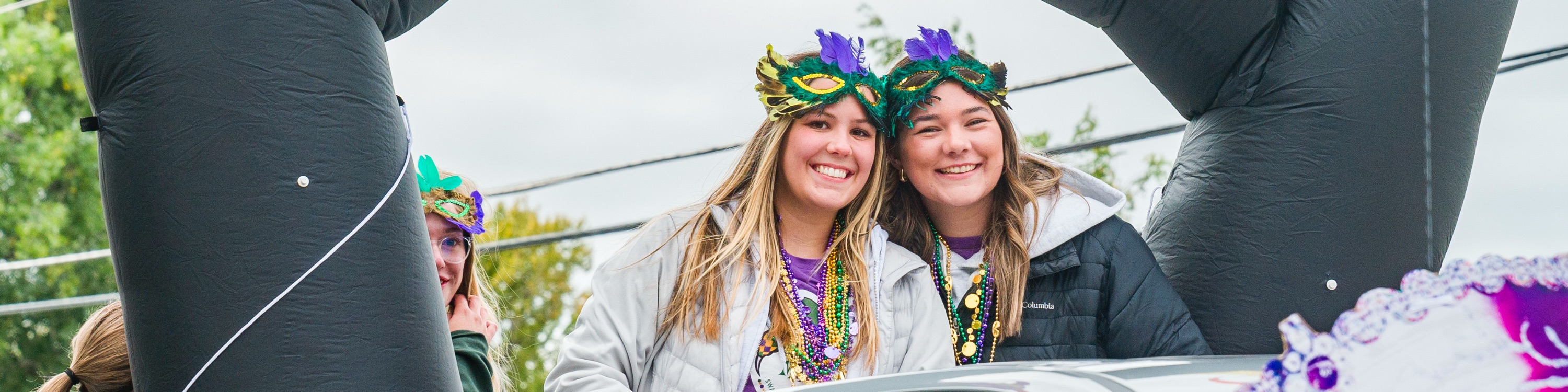 Banner image of 2 BHSU students on a Swarm Days parade float.