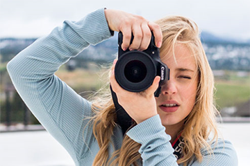 Woman holding camera and taking photo of someone taking a photo