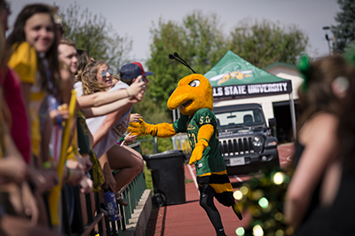 Sting high-fives fans at a home football game.