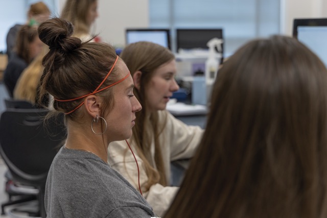 Female student with EEG monitoring equipment attached to her head during a neuromuscular research demonstration in the Exercise Science lab