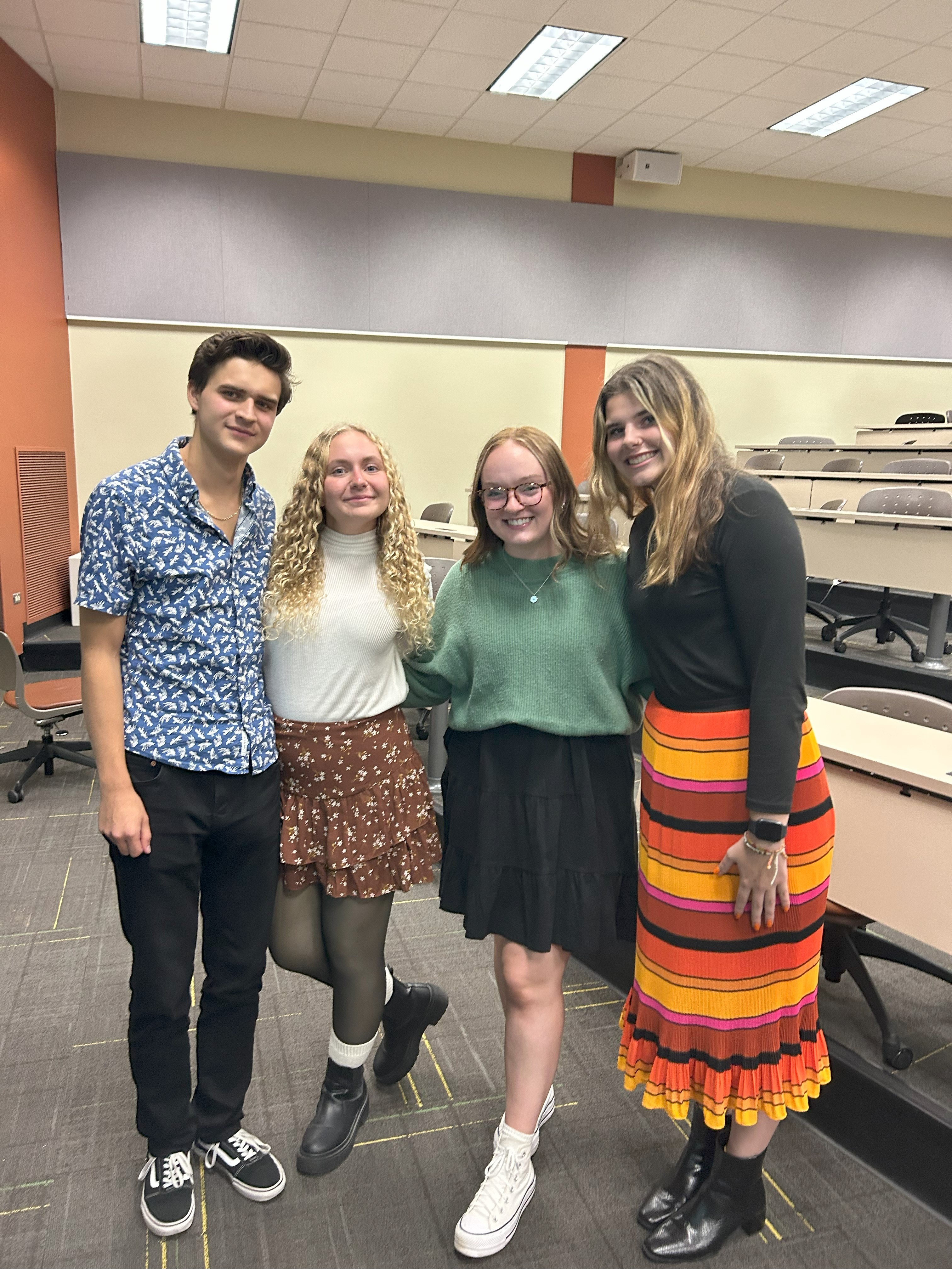 Four psychology club members pose for a photo after the Take Back the Night event.