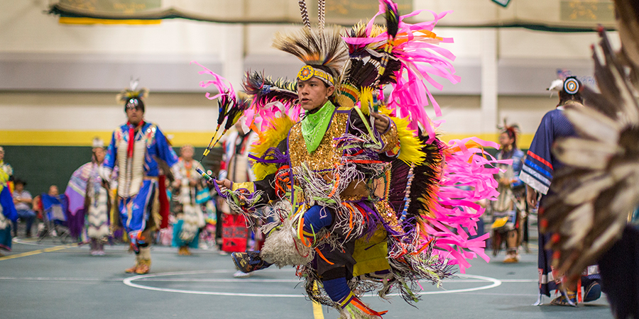 A Native American man dances at a powwow.