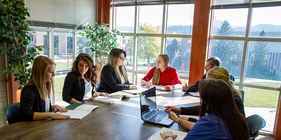 Seven students study at a table. 