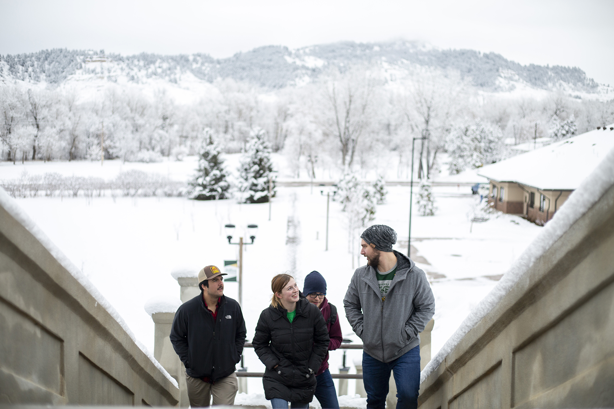 Four students explore campus in the snow.