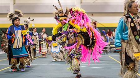 Native American men dance at a powwow.