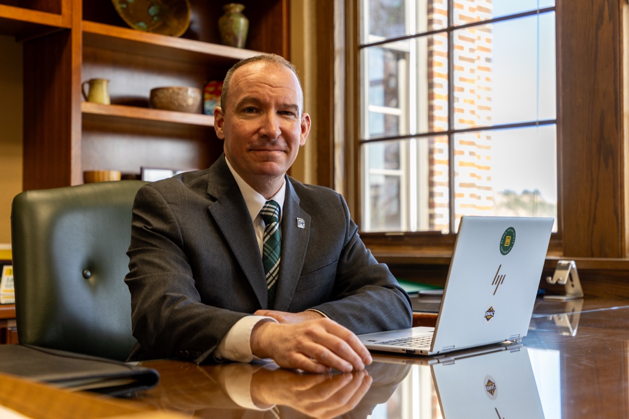 President Elliott sitting at his desk with his laptop.