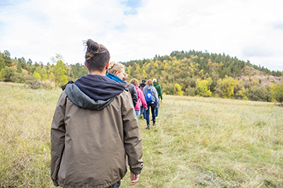 Students hike in a single file line in the Northern Hills.