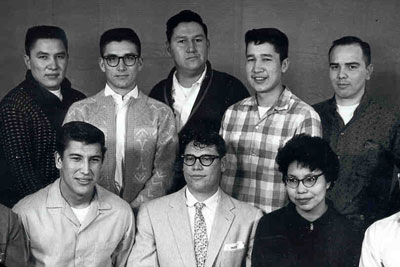 Eight indigenous people pose for a photo.