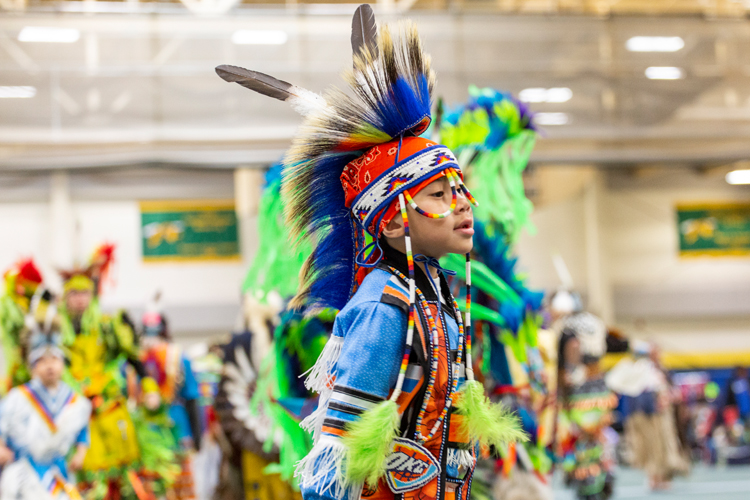 A Native American boy dances at a powwow. 