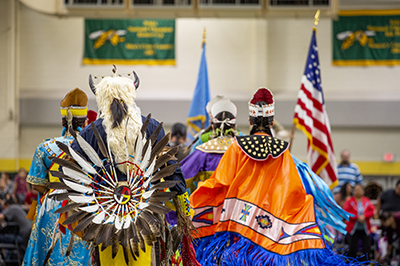 Four Native American men walk away from the camera.