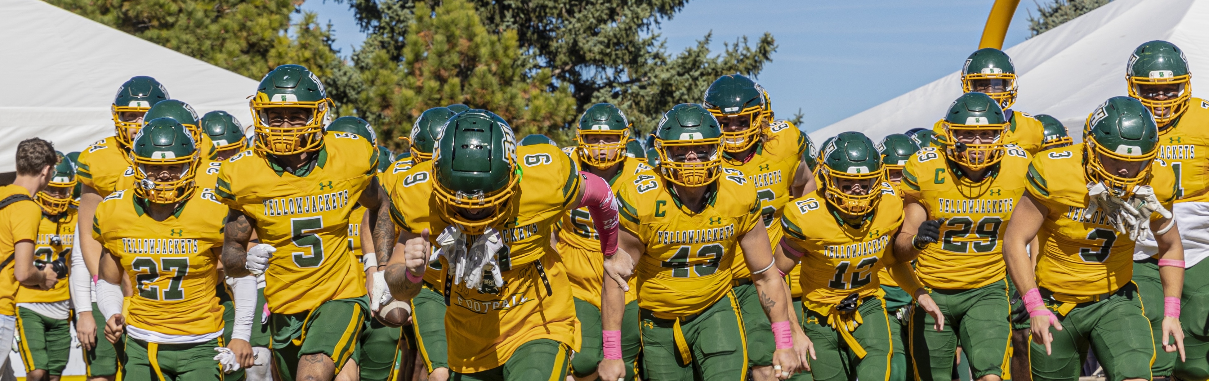 Banner image of BHSU football team running onto the field.