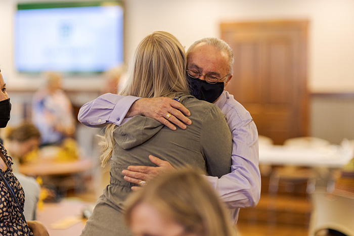 retiree hugging a woman at the retirement celebration at the Joy Center