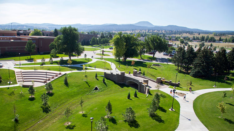 drone shot of students walking across campus with mountains in background