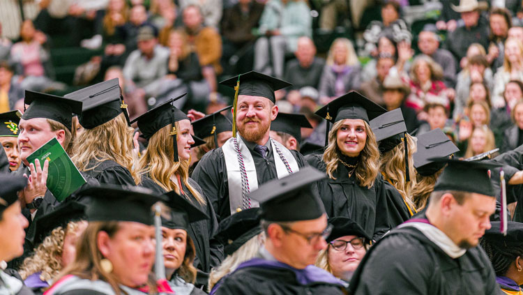 BHSU graduates stand in excitement at the Fall 2022 Commencement Ceremony at BHSU.