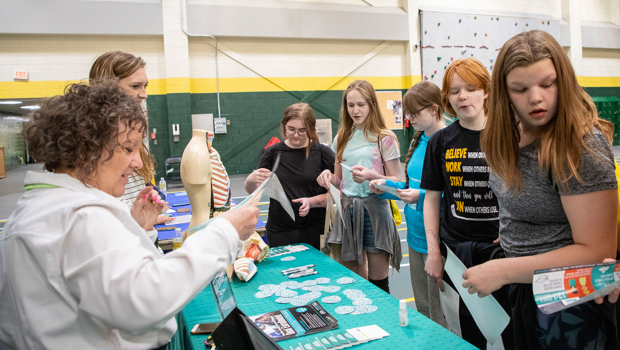 Students circle around a table during the Women in Science conference held at BHSU.