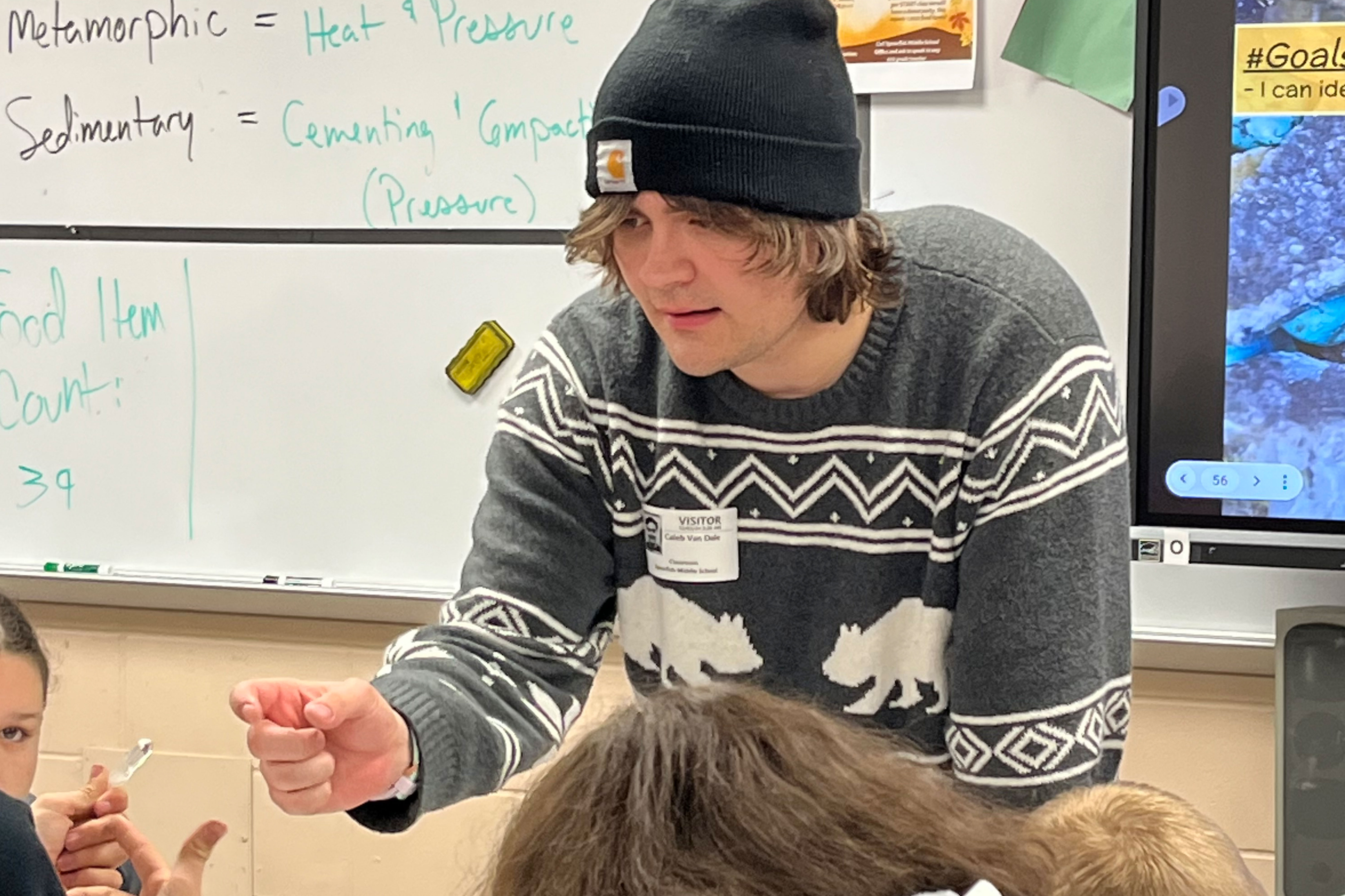 A BHSU student helps students in a Spearfish Middle School classroom learn about rocks and minerals