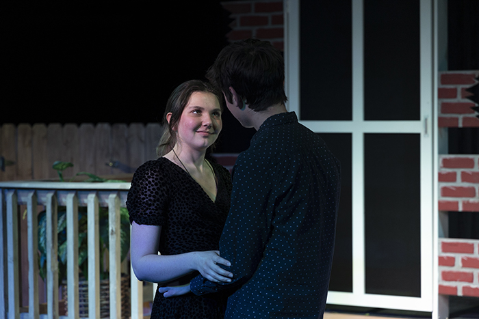 a girl facing towards us is looking at a guy who is embracing her
