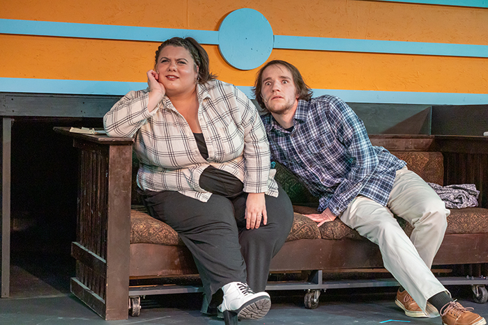 a man and a woman sitting with big eyes on a bench looking over the camera