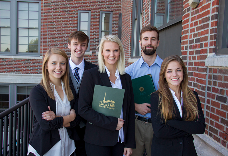 Five business students pose for a photo.