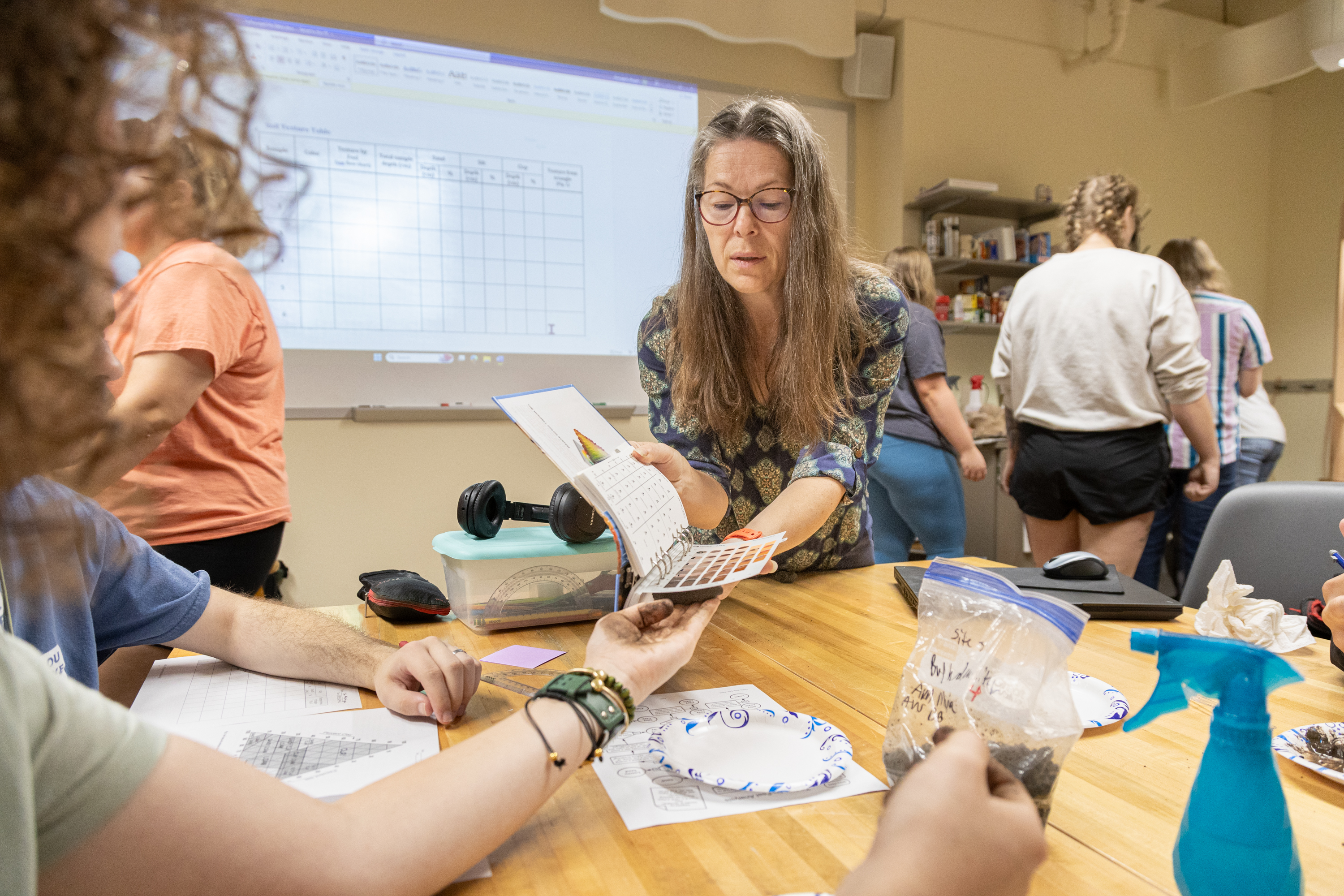 Dr. Abigail Domagall shows a Munsell Soil Color Chart to a student.