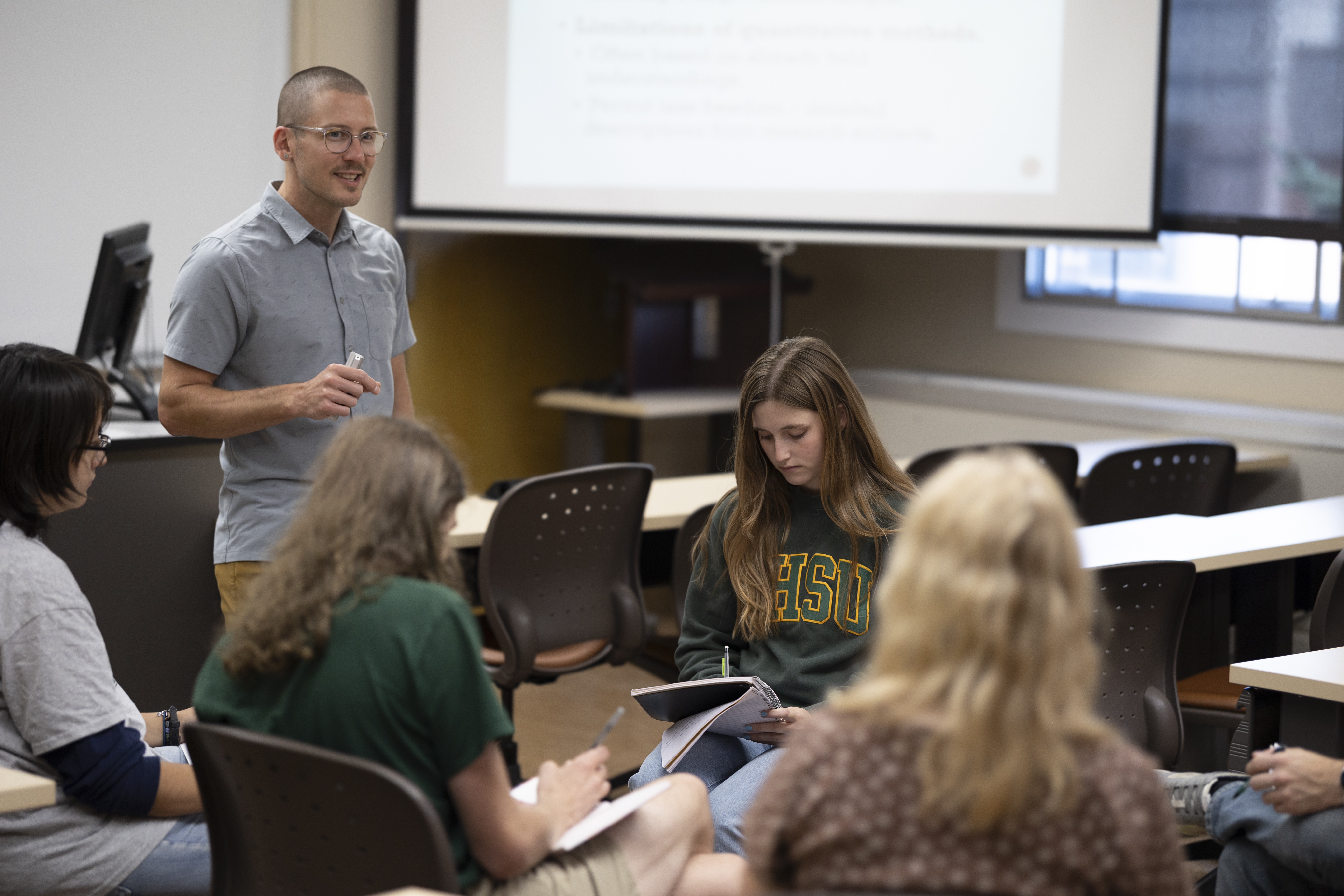 Professor Trenton Ellis lectures his students while they take notes.