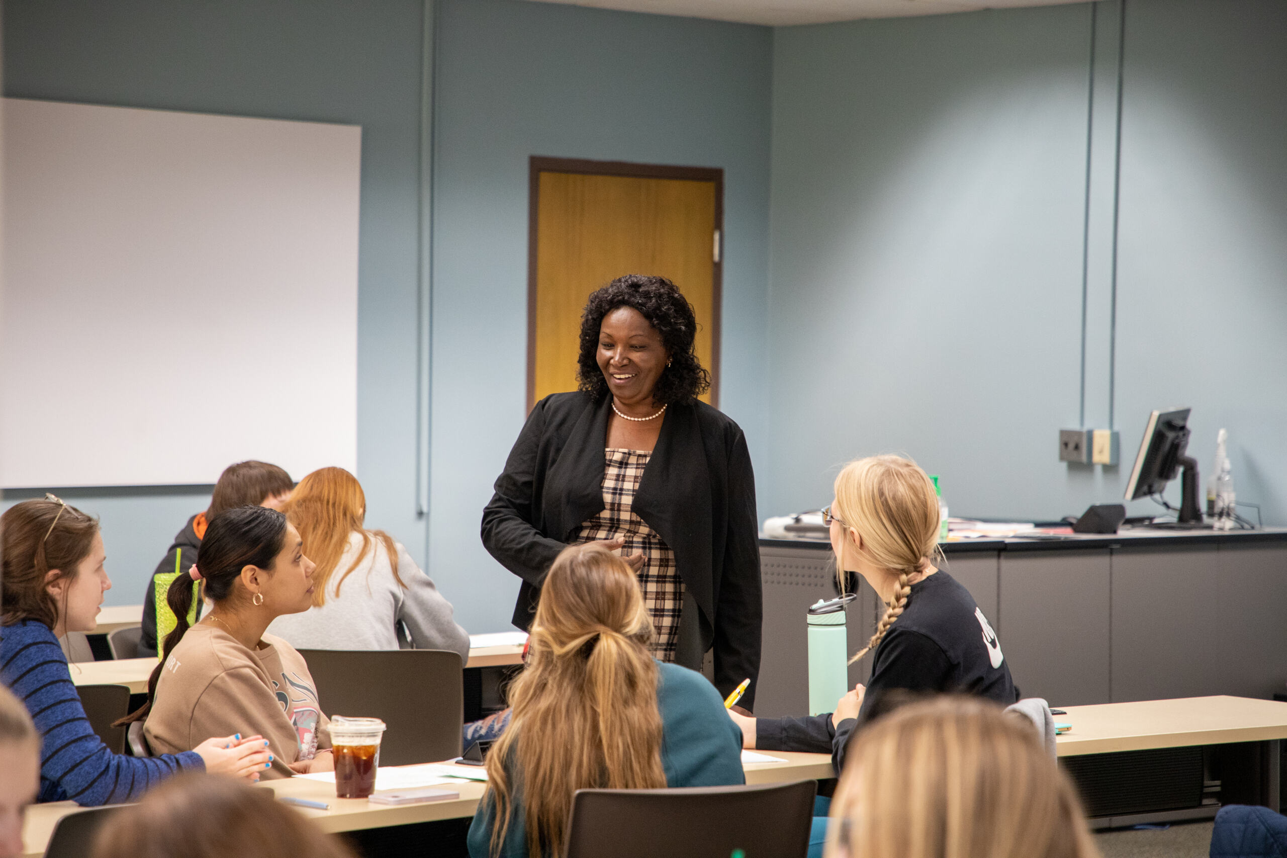 A professor speaks to a group of students in class.