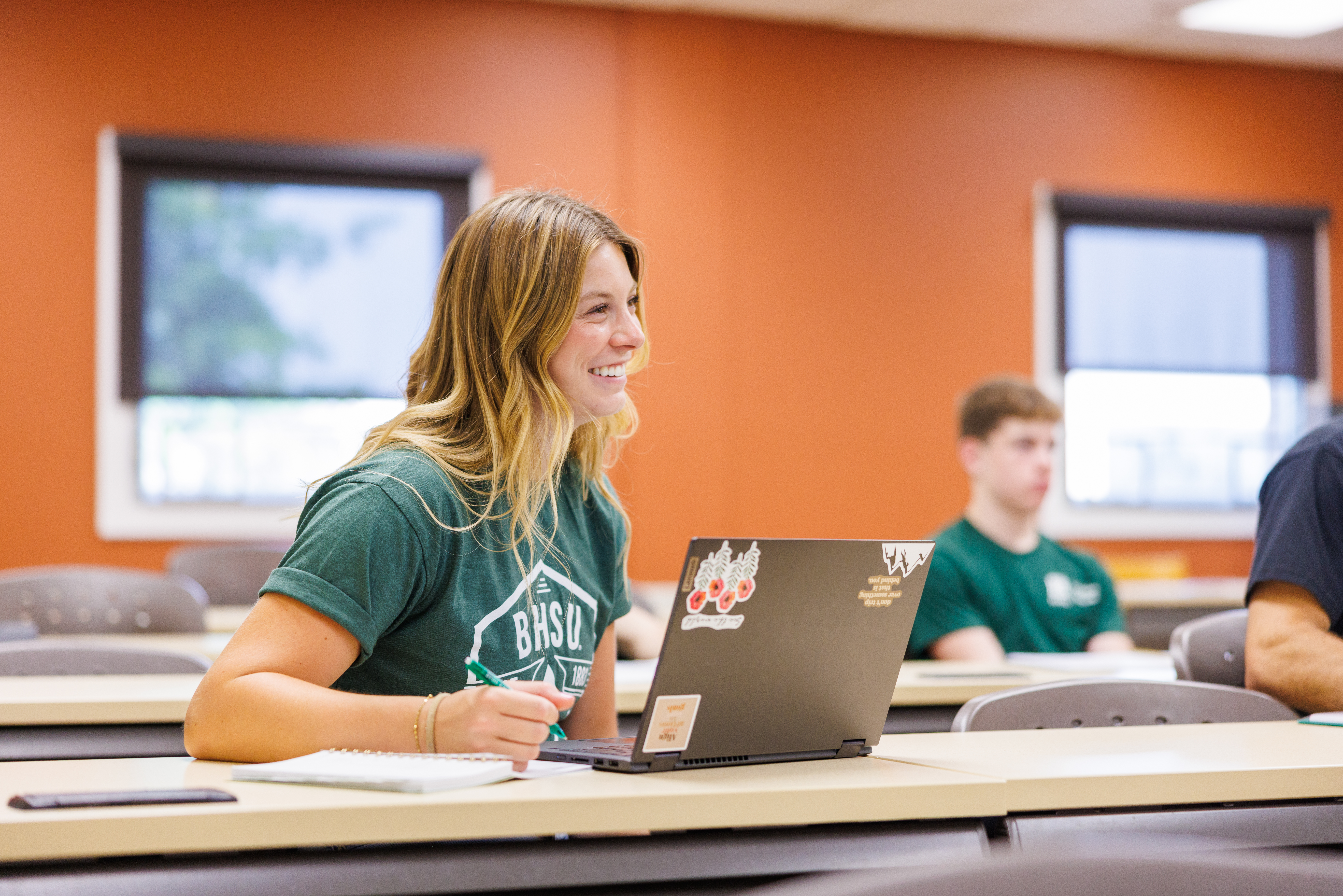 A BHSU student takes notes in class.