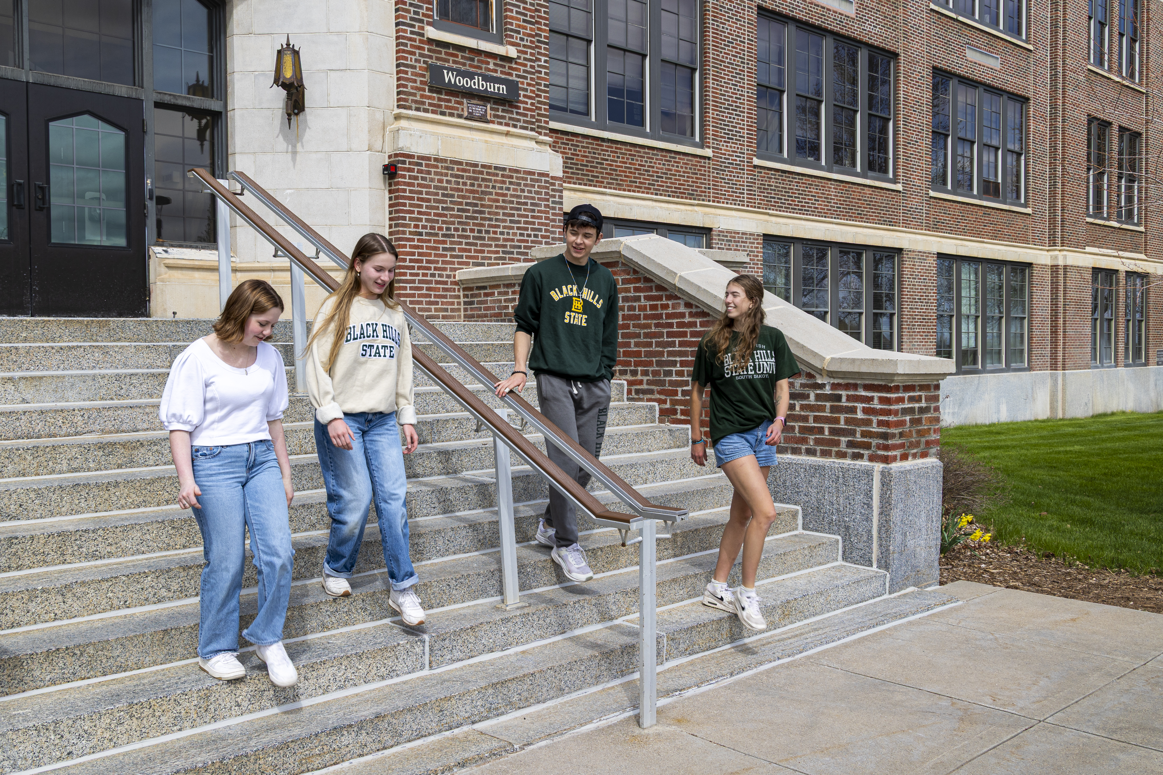 Four BHSU students walking down the stairs of Woodburn Hall.