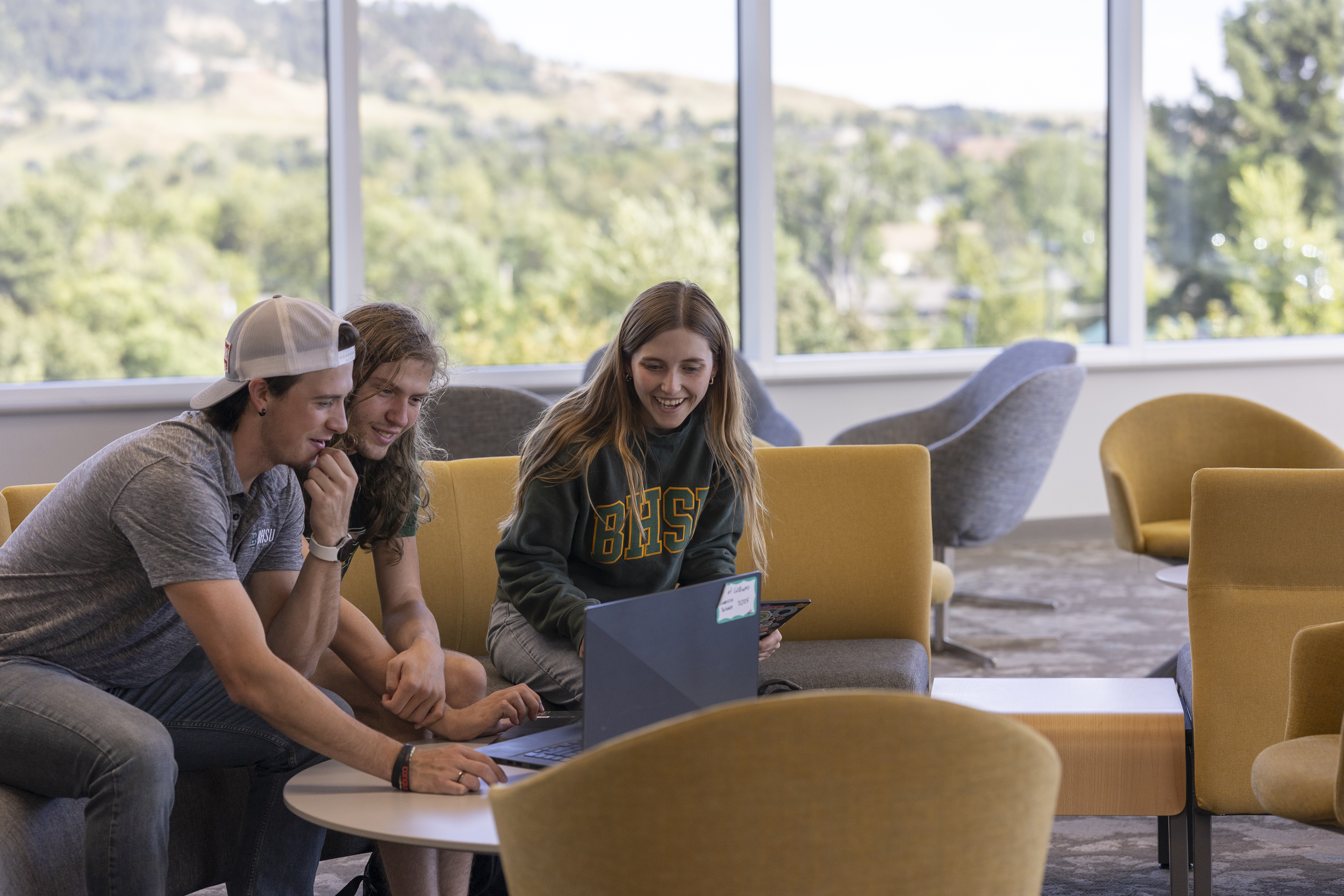 Three BHSU students work together in the library.