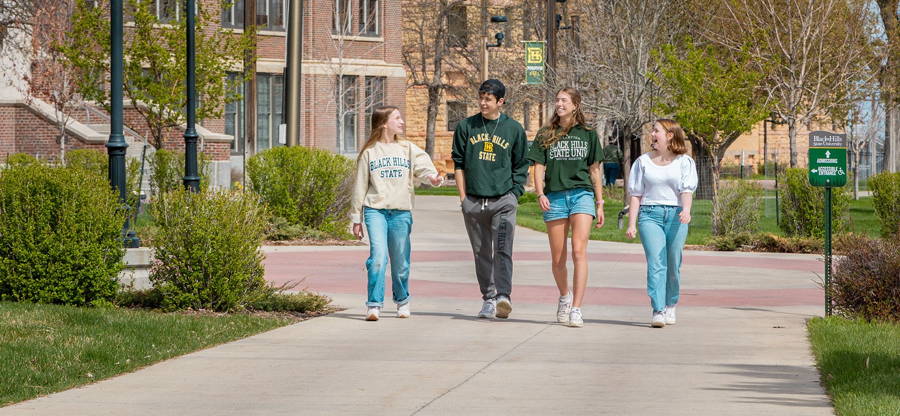 Four BHSU students walking outside of Woodburn Hall.