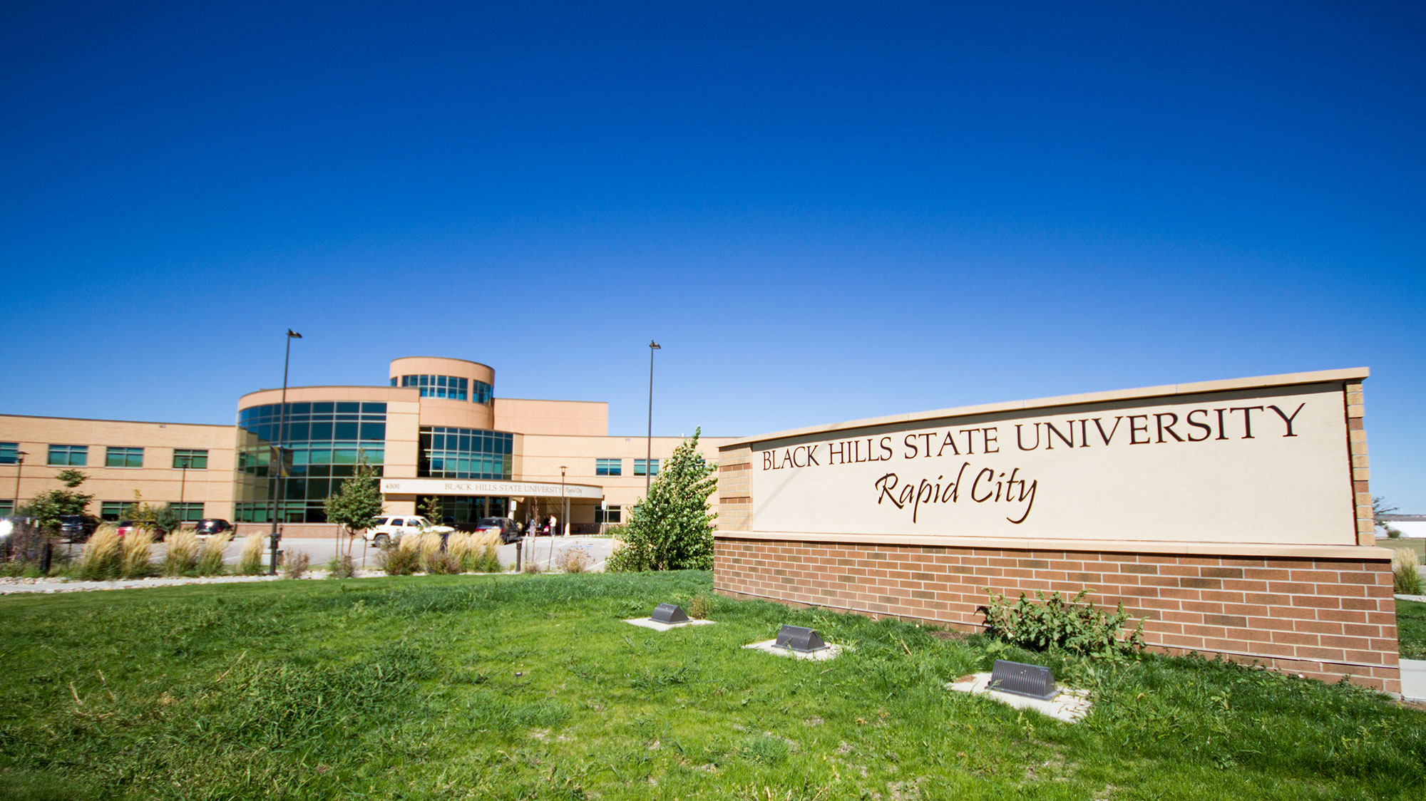 Image of the the Black Hills State University-Rapid City Building on a sunny day with green grass.