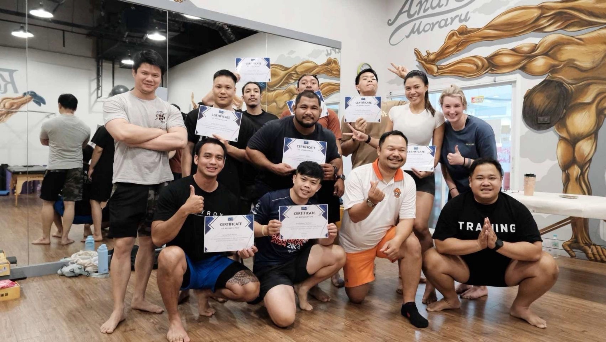 A group of people smile for a picture with certificates