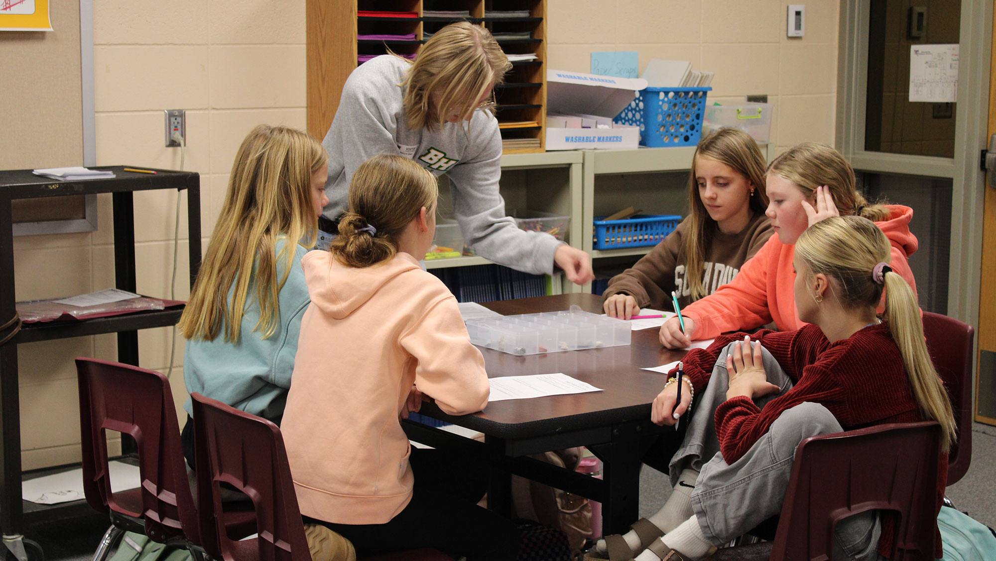 A BHSU student works with middle schoolers on a science experiment during their earth science class.