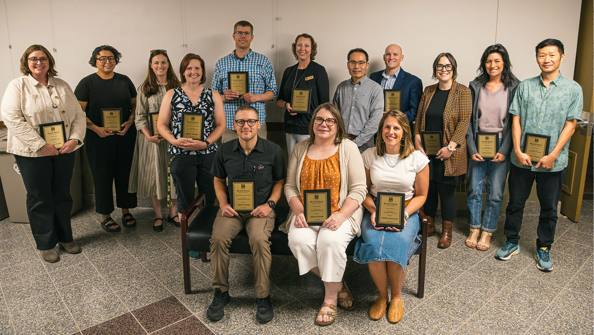 Recipients of Black Hills State University's 2025-26 faculty awards pose for a group photo while holding award plaques during Welcome Week in August. The awards recognize excellence in teaching, research, scholarship and creative activity, service, and mentoring across BHSU's four academic colleges.