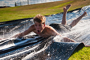 A male student uses the slip and slide at Green and Gold Days.