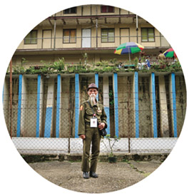 A man with a beard standing outside of a building.